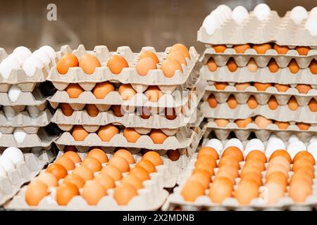 Stacked egg cartons filled with white and brown eggs on display, showcasing poultry farm produce ready for sale Stock Photo