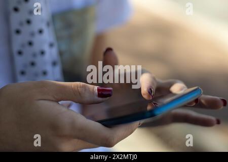 Close-up of the hands of a young Latin American woman (22) using her cell phone. Technology concept. Stock Photo