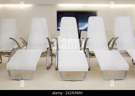 Two rows of white comfortable seats in empty room for waiting. Stock Photo