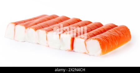 Row of eight bright red crab sticks isolated on white background. Stock Photo