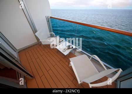 balcony with chairs table bottle glass binoculars on ship with view on sea Stock Photo