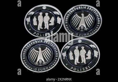 Hamburg, Germany. 23rd Apr, 2024. Four new 10-euro 'Police' commemorative coins lie on a tray in the Hamburg Mint. The collector's coin is part of the multi-year series 'In the service of society' and depicts several police officers on duty. Credit: Christian Charisius/dpa/Alamy Live News Stock Photo