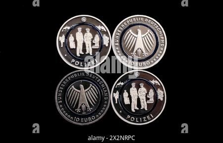 Hamburg, Germany. 23rd Apr, 2024. Four new 10-euro 'Police' commemorative coins lie on a tray in the Hamburg Mint. The collector's coin is part of the multi-year series 'In the service of society' and depicts several police officers on duty. Credit: Christian Charisius/dpa/Alamy Live News Stock Photo