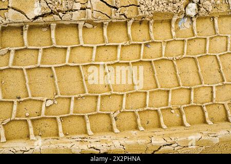 Car tire tread pattern prints in wet yellow sand, wheel protector marks texture, tyre tracks in sand, tire prints on a wet sandy road Stock Photo