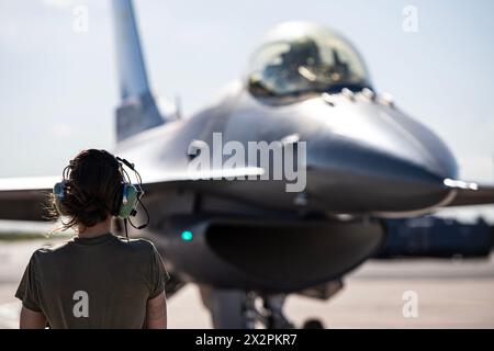 A crew chief assigned to the 140th Maintenance Squadron, Colorado Air National Guard, prepares to marshal an F-16C Fighting Falcon May 8, 2023, at Buc Stock Photo