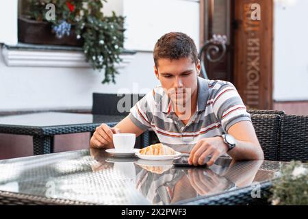 A Young Man Reads The News On The Device Stock Photo