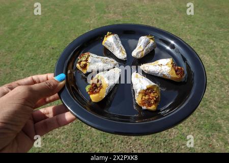 Female holding serving Paan flavoured Indian sweets. Paan barfi stuffed with Gulkand paan flavor. Paan burfi in dish Stock Photo