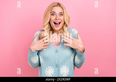 Portrait of ecstatic person with curly hairstyle wear blue cardigan astonished staring open mouth isolated on pink color background Stock Photo