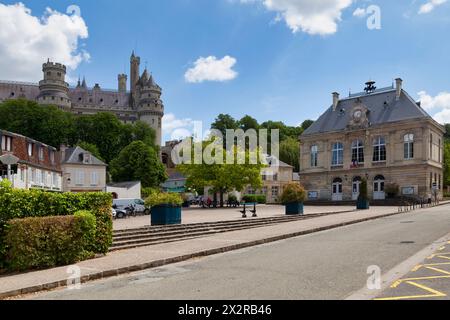 Pierrefonds, France - May 25 2020: The Place de l'Hôtel de ville with the town hall and the Pierrefonds Castle overlookng it. Stock Photo