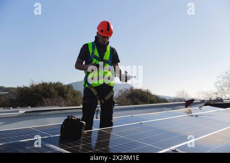 Mature technician with drone standing by solar panel Stock Photo