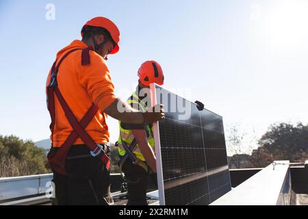 Two engineers installing solar equipment on rooftop3 Stock Photo