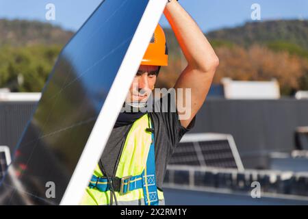 Mature worker carrying solar panel on sunny day Stock Photo