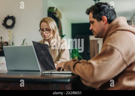 Software programmers working on laptop at home office Stock Photo