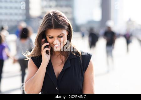 Smiling young woman talking on smart phone Stock Photo