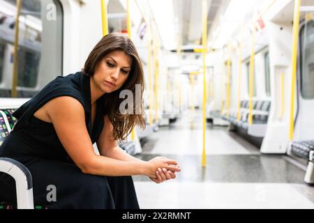 Thoughtful sad woman sitting in subway train Stock Photo