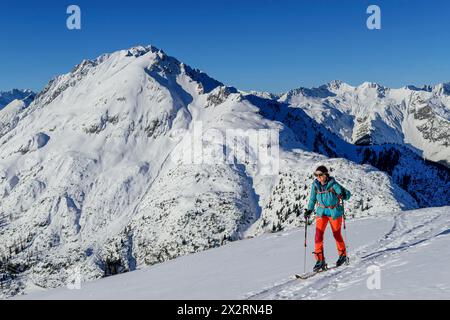 Mature woman back country skiing on Gruenstein with Lechtal Alps in background, Mieming Range, Tyrol, Austria Stock Photo