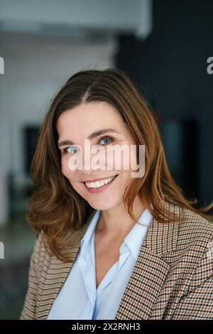 Confident mature businesswoman in blazer at office Stock Photo