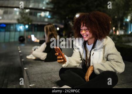 Young women using smart phones at night Stock Photo