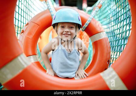 Smiling girl playing at rope park Stock Photo