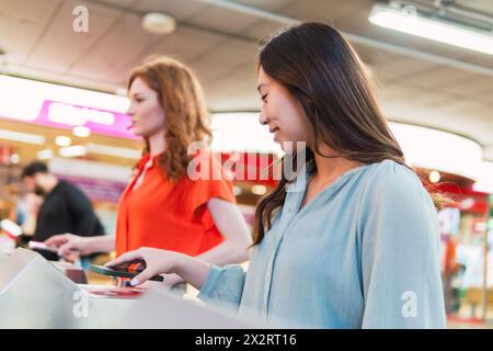Young friends scanning QR code through smart phones at station Stock Photo