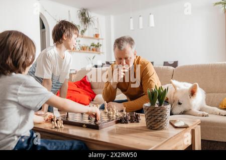 Father and son playing chess on table at home Stock Photo