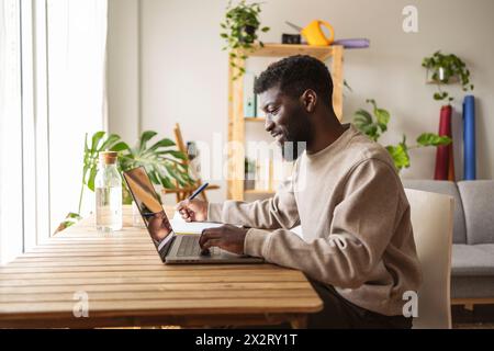 Smiling freelancer working on laptop at home Stock Photo