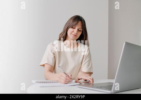 Businesswoman writing in diary and working at home office Stock Photo