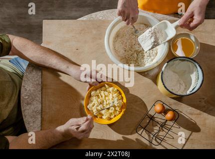 Senior couple preparing dough on table at home Stock Photo
