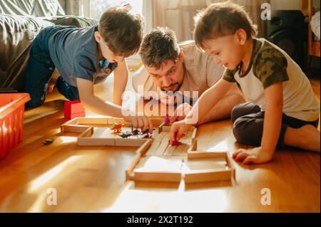 Siblings playing with toys near father at home Stock Photo