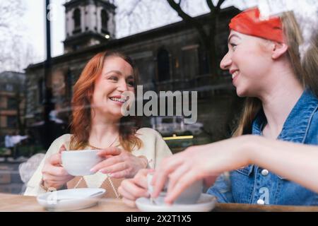Happy friends having coffee together in cafe Stock Photo