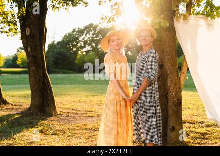 Friends holding hands standing in park Stock Photo
