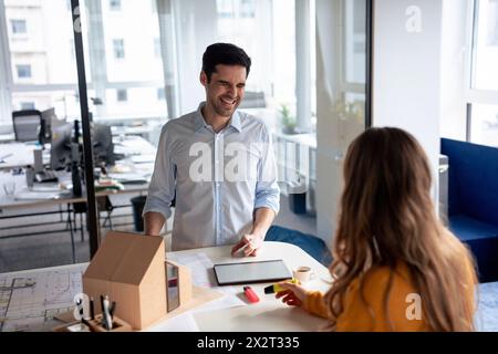 Happy architects with model house and blueprints at desk Stock Photo