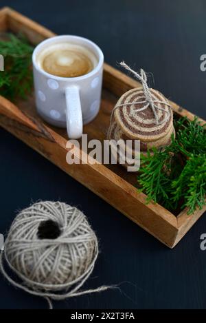 Cookies, fir tree twigs and mug of coffee on wooden tray Stock Photo