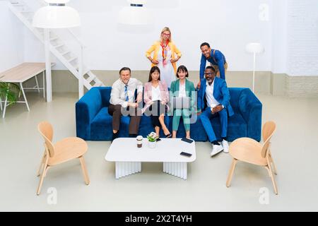 Business team sitting together on sofa at office Stock Photo