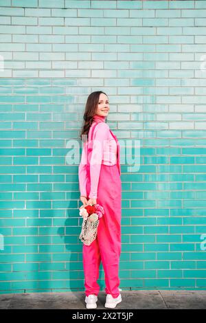 Smiling woman holding roses looking back over shoulder Stock Photo