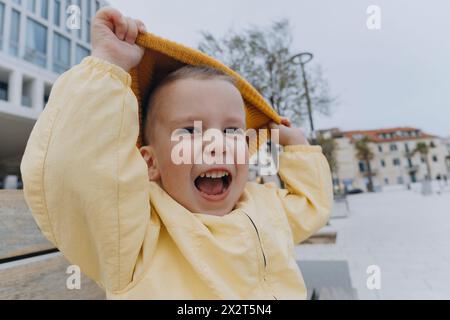 Cute boy playing with orange knit hat Stock Photo