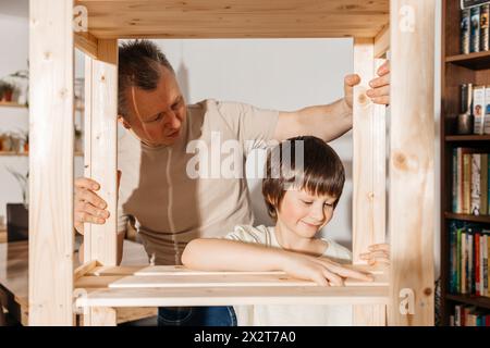 Father and son assembling wooden rack together at home Stock Photo