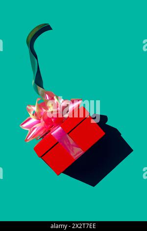 Red gift box against green background Stock Photo