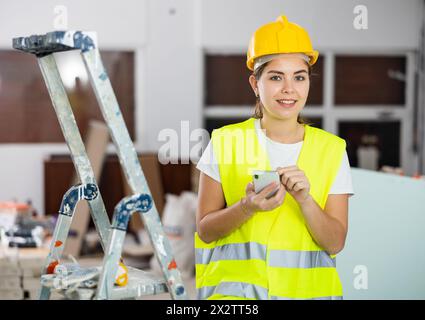 Young woman engineer using smartphone in construction site Stock Photo