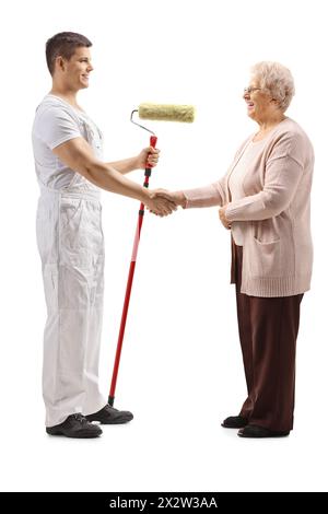 Full length profile shot of a decorator and elderly woman shaking hands isolated on white background Stock Photo
