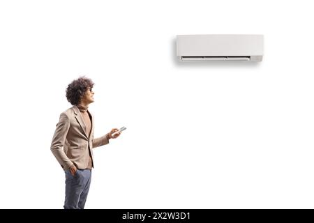 Young man putting on an air conditioner mounted on wall isolated on white background Stock Photo
