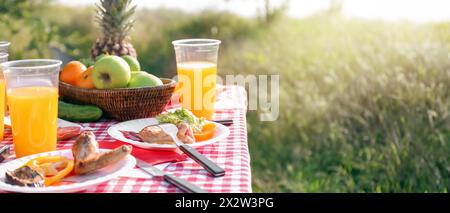 Tasty food prepared for picnic on table outdoors Stock Photo