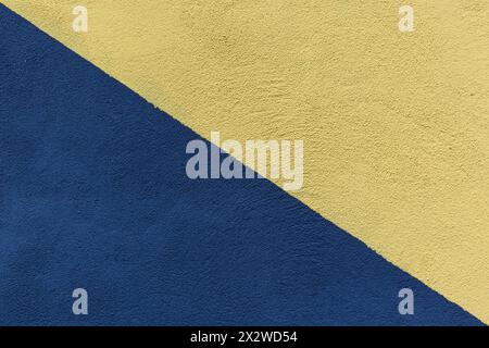 Colored paper in blue and yellow, divided in half, diagonally background Stock Photo