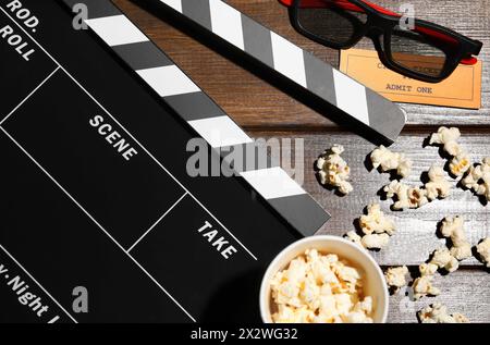 Flat lay composition with clapperboard and popcorn on wooden table Stock Photo
