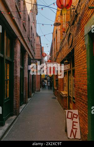 Victoria, Canada - Mar 17 2024: A photo of the narrow, snug and shady Fan Tan Alley with its shop signs and chinese good luck lanterns hanging from th Stock Photo