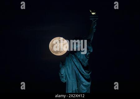Jersey City, Nj, United State. 23rd Apr, 2024. The Pink Moon, illuminated at 100 percent, rises behind the Statue of Liberty in New York City on April 23, 2024. (Credit Image: © William Volcov/ZUMA Press Wire) EDITORIAL USAGE ONLY! Not for Commercial USAGE! Stock Photo