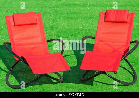 Two deck-chairs on the field with green grass Stock Photo