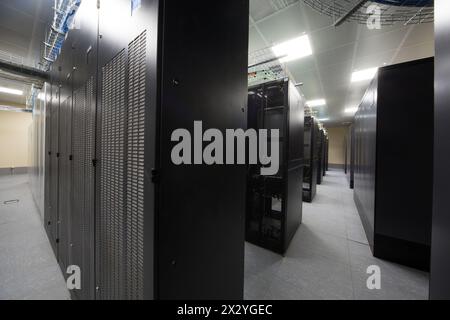 Telecommunication racks in the server room with lots of cables. Stock Photo