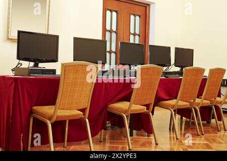 Desktop computers on table in auditorium Stock Photo