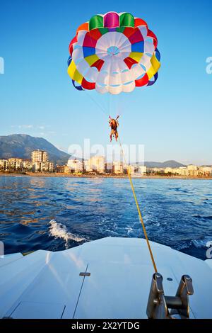 Woman and boy fly on glider over sea Stock Photo